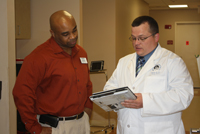 Matthew Ard PA - C and Health Navigator discuss a patient's chart