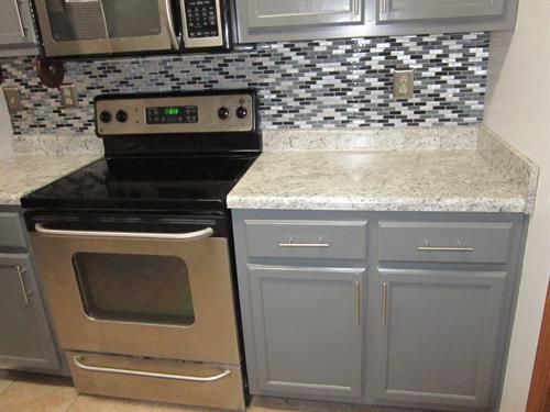 Updated kitchen with new backsplash tile and durable counters installed by Lucius.