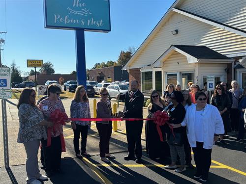 Staff and trustees cut the ribbon on Ancora's new building October 2024. The building houses their Serious Illness Clinic, their new resale shop, and their new counseling center.