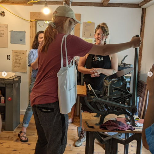 A Writing Retreat Student Tests out the Platen Press