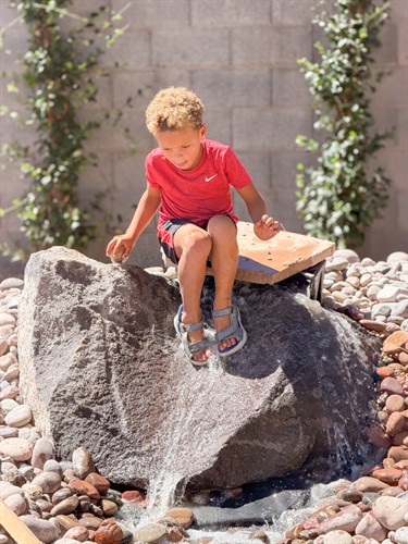 Acton Academy St. George leaner playing in water feature