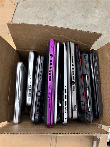 A box of laptops waiting to be processed and recycled.