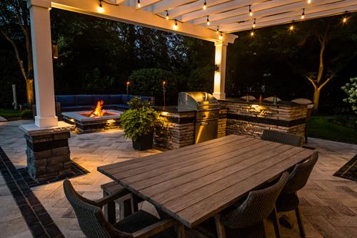 A mix of subtle landscape lighting and festive cabana lights create a safe and inviting family space.