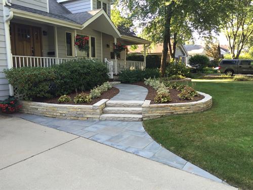 The curved bedline draws the eye to the entrance, while bluestone and flagstone complement the house perfectly.