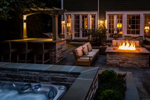 We turned an undersized patio into a relaxing retreat with a fire table, outdoor kitchen, and beautifully disguised hot tub.  