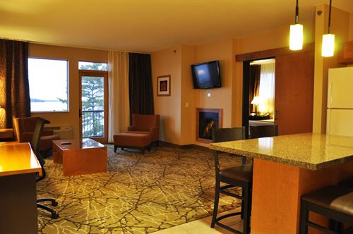 Hotel - Premier Suite - King Bedroom, living area with Queen pull-out bed, fireplace, televisions, private balcony, whirlpool bath, and kitchenette.