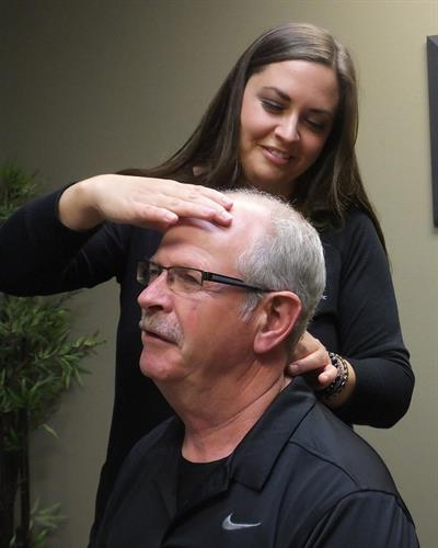 employee adjusting a male clients neck