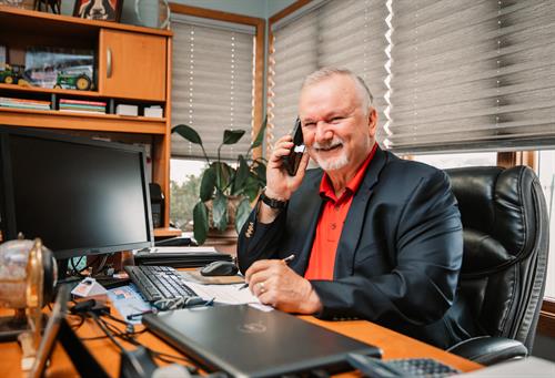 Daryl Pulsfus answering a phone call at his desk