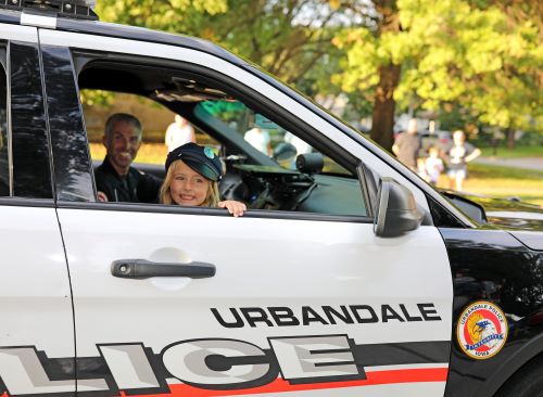 Girl in police car at Urbandale Homecoming Parade