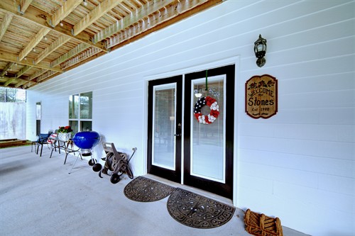 Private keypad entrance with a spacious patio featuring elegant lighting and comfortable seating—perfect for outdoor dining and relaxation.