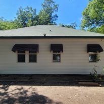 Vinyl siding install with green trim.