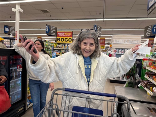White Flag client leads to joy while learning technology during grocery shopping!