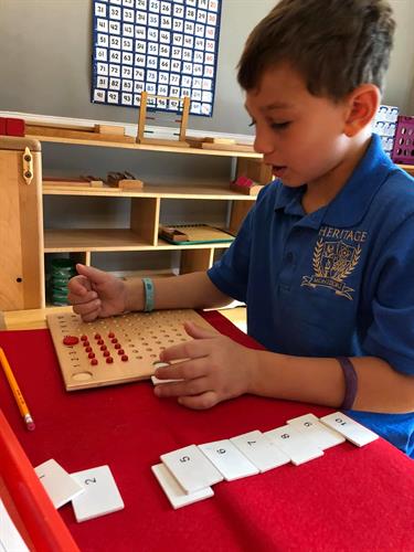 Primary Student working on the Times Bead Board