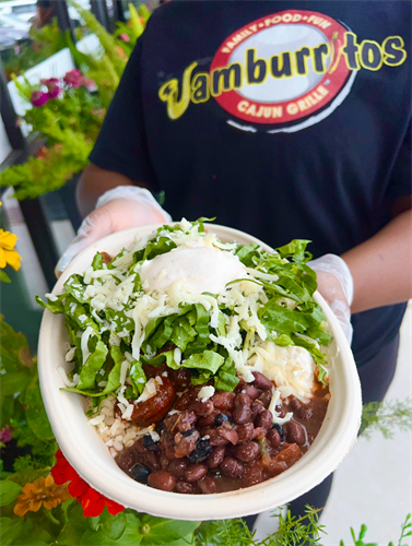 Shrimp bowl with jambalaya rice, black bean salsa, Monterey Jack cheese, romaine lettuce, and sour cream.
