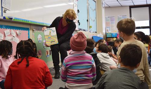 Volunteer reads to students at Morningside Community School