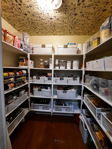After - Zones and categories were created in the pantry for ease of access. Client had some wallpaper laying around and we had it installed on the ceiling for extra touch