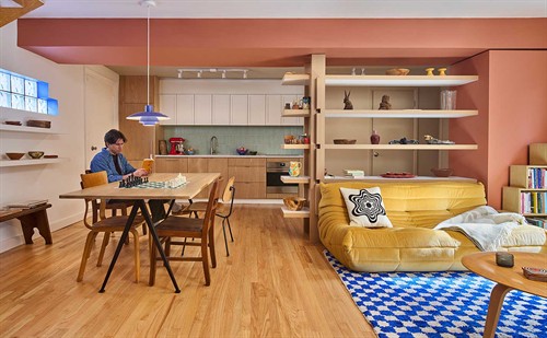 In this modest renovation of a 19th-century carriage house, one room becomes a space of many functions.  A new compact kitchen and integrated custom shelving maximize spaces for storage and display while partitioning the 500 SF room for greeting, eating, and resting.