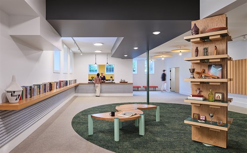 This renovation for a community church transforms an uninviting basement into a place for spirited assembly with custom-designed furniture around the hall’s existing columns and felt forms that animate the space while providing warmth and dampening sound.