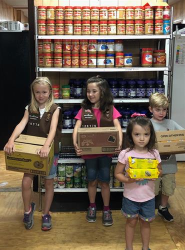 Brownie Troop shares cookies with the MESA's Food Pantryclients