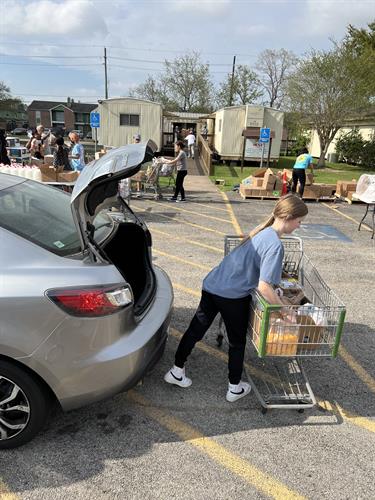 Loading a client's car with groceries at drive through distribution