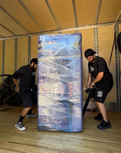 Cypress moving company loading a protected fridge into the truck