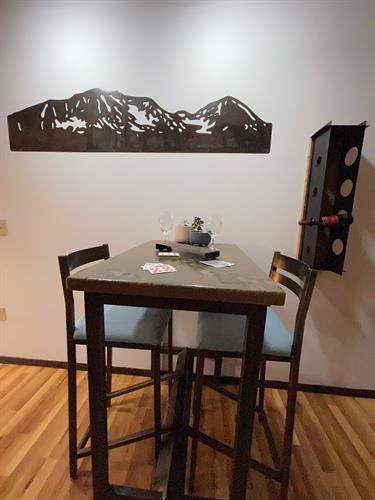 Room by CCMT, one of a kind steel and concrete hightop set, Great Northern metal wall art, reclaimed wood and steel wine rack and one of a kind steel cribbage board complete with hand made pegs. 