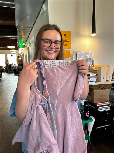 A member showing off her hand-mended garment.