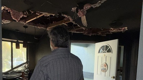 Inspecting a fire-damaged room with a collapsed ceiling