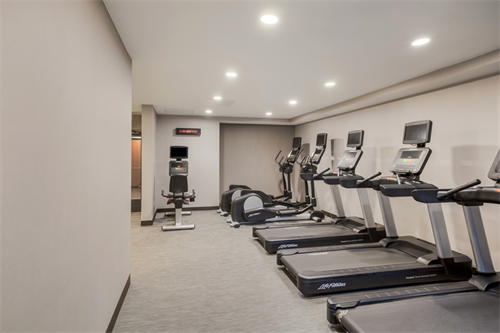 Expansive fitness spaces include multiple treadmills and a weight area