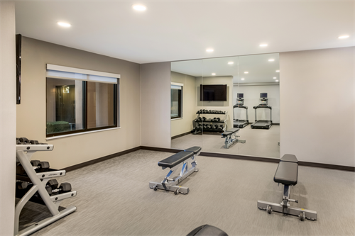 Expansive fitness spaces include multiple treadmills and a weight area