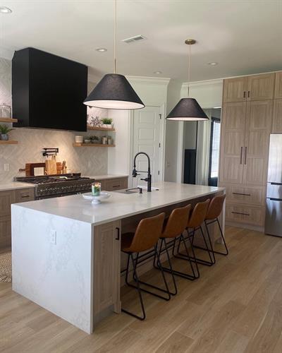 Enhance your space with stunning Calacatta countertops paired with Nooci1 cabinets and a chic white herringbone backsplash, creating a harmonious blend of elegance and modern design.