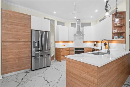 We are thrilled to showcase our latest project, where we not only remodeled this client's kitchen but also transformed two bathrooms and converted a bedroom into a  kids' layroom for their grandchildren. The heart of the home, the kitchen, features stunning cabinetry by Lioher in Blanco & Nocce 1,complemented by exquisite Calacatta Supreme quartz countertops.