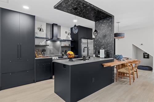 We Remodeled this kitchen and modernized it with sleek black Lioher high gloss cabinets. The table is built in and wraps around the island. It has Calacatta Quartz countertops and Backsplash. 