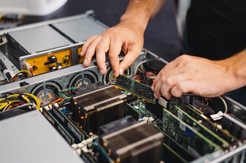 Precision at work: hands-on with circuit boards inside a complex computer system.