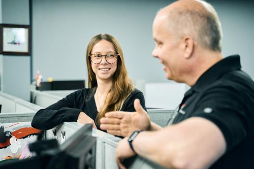 President Bill Thousand and Account Manager Jordan connect over strategy in a casual office moment.