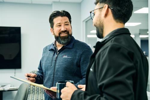 Engineer Dan and Account Manager Matias conferring over coffee.