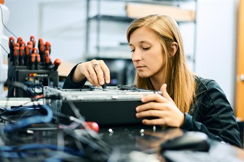Focused and hands-on: Technician Kireina fine-tunes a computer component with precision and care.