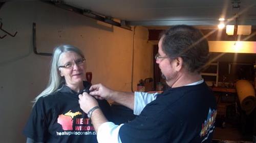Chris Pramas pins on a micro phone for Heat Up Recipient Cheryl Brock before her interview with NBC 15.  Cheryl was nominated and received a free furnace from Lennox Industries and Accu-Clime Mechanical Services LLC to have a free furnace installed in her home October 6th, 2012.