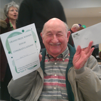 An RFCU member shows off his $350 cash grand prize at our 2013 annual meeting.