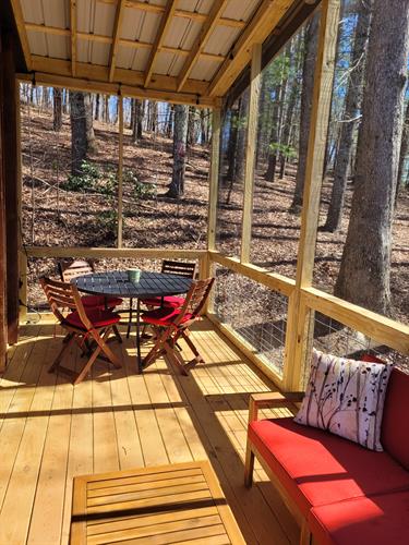With an outdoor dining table, couch and chaise with coffee table, and 4 comfortable Adirondack chairs, the screened in porch is perfection.