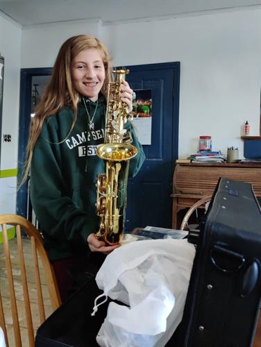 A student with her new saxophone provided by CAC (November 2021).
