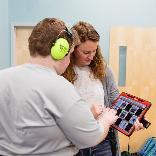 A student communicates with a Birchtree staff member using a tablet.