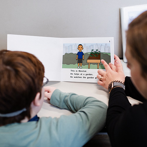 A Birchtree instructor and student study a book together.