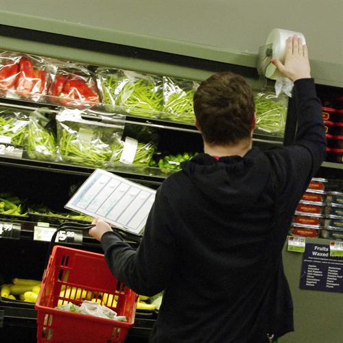 Student learning independent-living skills while shopping at a local store with support from a Birchtree instructor