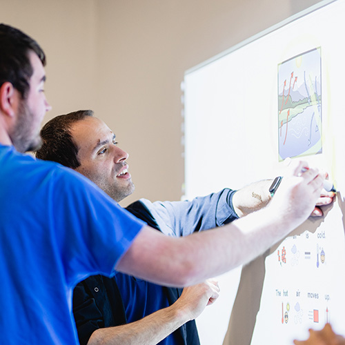 A student does a lesson with an instructor using a smart projector at Birchtree's day school.