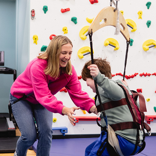 A student swings in the gym at Birchtree's day school.