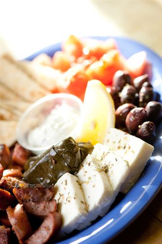 Meze Appetizer Plate. Feta cheese, kalamata olives, tomato wedges, stuffed grape leaves, loukanico (Greek Sausage), pita wedges and tzatziki sauce.