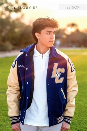 High school senior portrait in a letterman jacket, photographed at sunset in Montgomery County