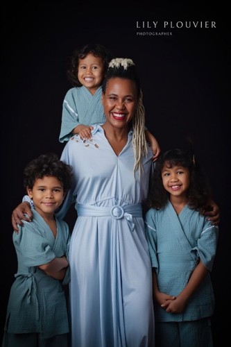 Fine art family portrait of a mother and her children on a dark studio backdrop