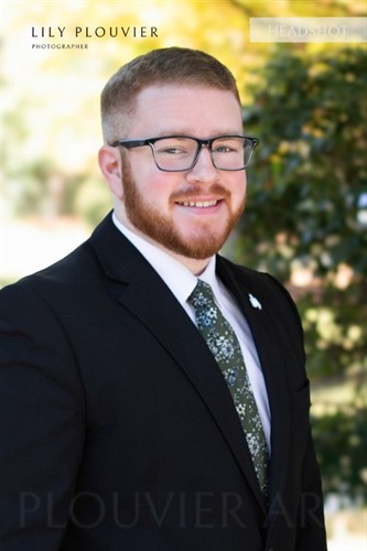 Corporate headshot with a natural outdoor background, photographed in The Woodlands